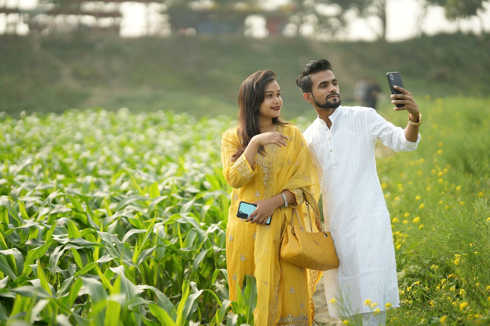 Young couple in traditional clothes taking a selfie on their smartphones